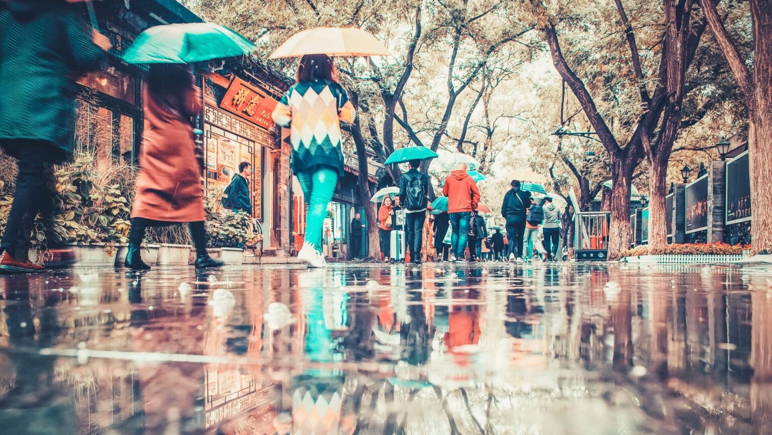 傘をさしている人たちが町の中を歩いている